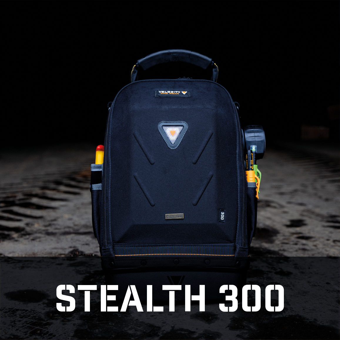 Velocity Stealth 300 Service Tool Bag with tools on the outside sitting in a warehouse with white text